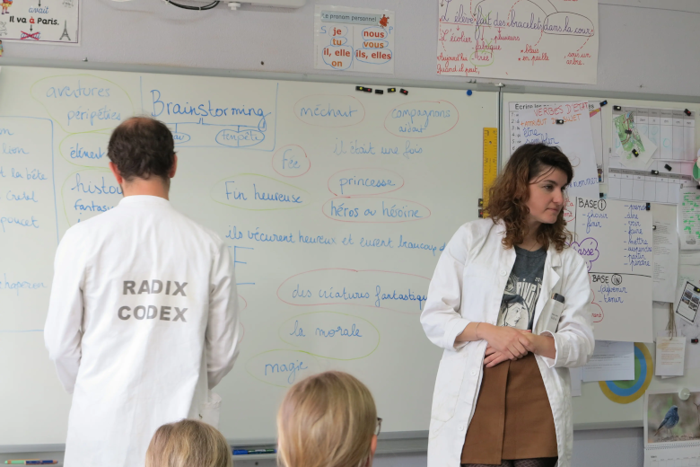Sarah et Charles devant un tableau de brainstorming à l'école de Caylus